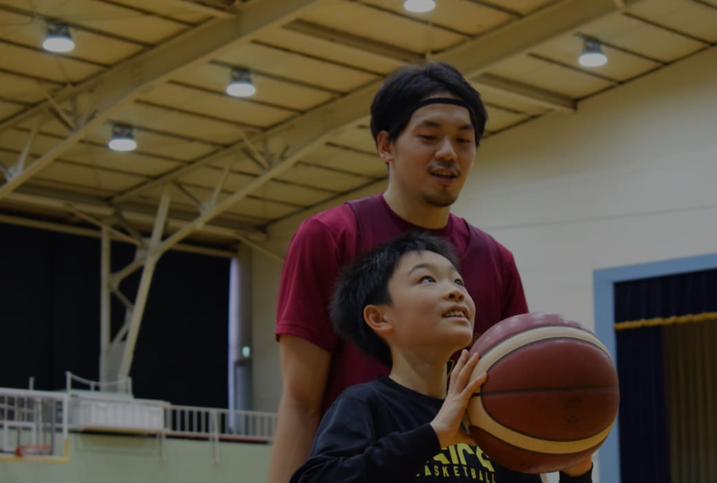 選手と一緒に車椅子に乗りながらバスケットボールを楽しむ子